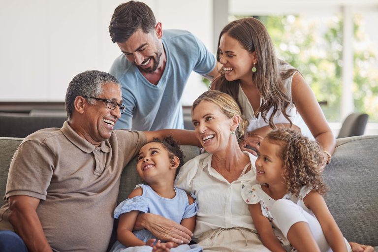 A smiling family sitting on a couch.